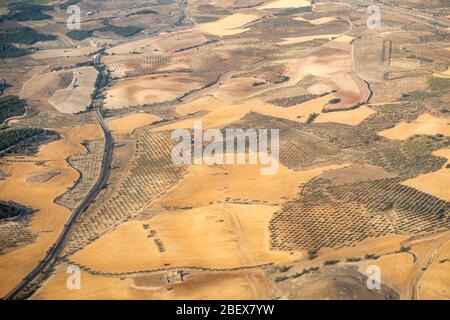 Luftaufnahme der Region Madrid, außerhalb des Ballungsraums. Fliegen über landwirtschaftliche Felder und Straße. Spanien Stockfoto