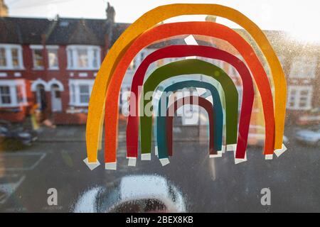 Willesden, London, Großbritannien, 27. März 2020 EIN Regenbogen klebte an der Innenseite eines Fensters in einer Show der Unterstützung für die NHS und andere wichtige Arbeiter, während des C Stockfoto