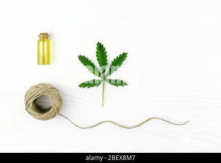 Cannabis Seil, Öl und Hanfpflanze auf dem weißen Holzhintergrund. Stockfoto