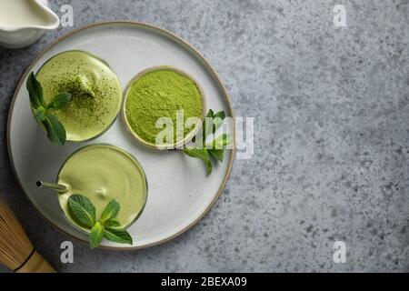 Dalgona Iced Matcha Tee. Geschlagenes weißes Ei mit Matcha-Tee wird der Milch mit Eis hinzugefügt. Schmackhaftes virales Getränk in der Zeit Selbstisolierung. Blick von oben. Stockfoto