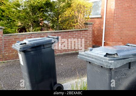 Müllcontainer vor Doppelhäusern am Morgen Newtownabbey Nordirland 2 m auseinander für soziale Distanz Stockfoto