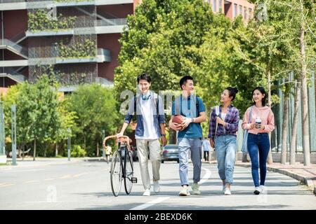 Die Sonne glücklich Studenten zu Fuß in den Campus Stockfoto