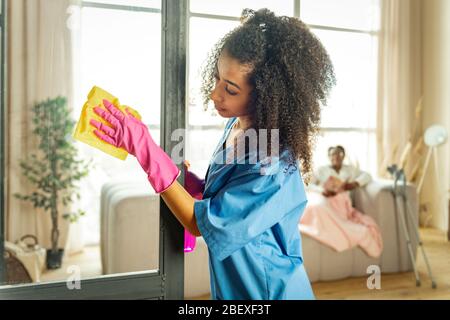 Nette afroamerikanische Frau, die die Reinigung macht Stockfoto