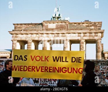 Die westdeutschen Bürger Anzeige ein Banner, wie Sie eine Mahnwache für den Abriss der Berliner Mauer am Brandenburger Tor. Ein Teil der Mauer wurde bereits am Potsdamer Platz abgerissen. Stockfoto