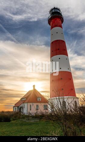 Leuchtturm Westerhever in der Nähe von Sankt(St.) Peter Ording bei Sonnenuntergang mit wunderschönem Himmel und dramatischen Wolken Stockfoto