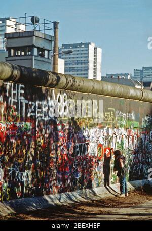 Einem Westdeutschen Kind versucht, Chip, ein Stück der Berliner Mauer als Souvenir. Ein Teil der Mauer wurde bereits am Potsdamer Platz abgerissen. Stockfoto