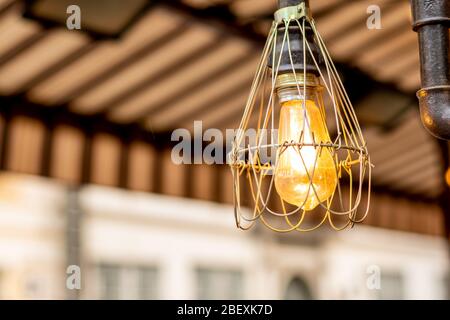 Moderne Lampe aus Metall mit Edison-Lampe im Café im Freien Stockfoto