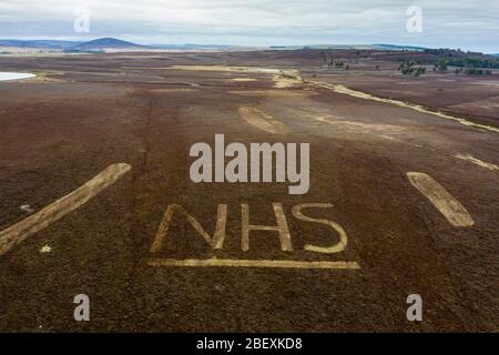 Greenlaw, Schottland, Großbritannien. 16. April 2020. Die Wildhüter haben die Buchstaben NHS in Heidekraut auf einem Hügel am Greenlaw Moor in Solidarität mit NHS-Arbeitern geformt, die an der Vergangenheit vorbeifahren. Sie nahmen sich im Rahmen der saisonalen Brandschutzmaßnahmen Zeit, Heideflächen zu mähen und zu mähen, um ihre Unterstützungsbotschaft zu mähen. Iain Masterton/Alamy Live News Stockfoto