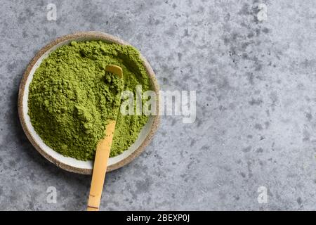 Japanischer Matcha-Pulver grüner Tee auf grauem Steintisch. Platz für Text. Blick von oben. Stockfoto