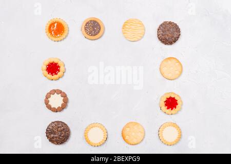 Quadratischer Rahmen aus Cookies mit freiem Raum im Inneren auf weißem Hintergrund. Platz für Text. Ein herzlicher Gruß. Kopierbereich. Flaches Lay. Draufsicht. Stockfoto