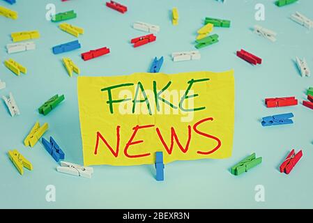 Handschrift Text Schreiben Fake News. Konzeptionelle Foto falsche Informationen veröffentlichen unter dem Deckmantel der authentischen Nachrichten farbigen Wäscheklammer Papiere leer Stockfoto
