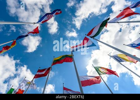 Flaggen der EU-Mitgliedstaaten winken im Wind mit blauem Himmel und schönen weißen Wolken vor dem Gerichtshof in Luxemburg. Stockfoto