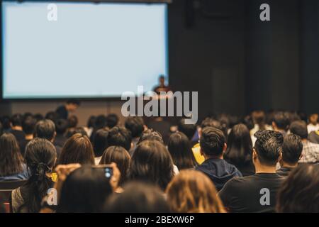 Rückansicht des asiatischen Publikums, der mit dem Sprecher auf der Bühne im Seminarkonferenzraum oder im Konferenzsaal, in der Ausbildung und im Workshop spricht, Stockfoto
