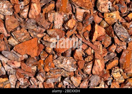 Nasse Steine von rot-grauer Farbe, Hintergrund aus Granit Stockfoto