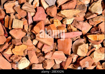 Kleine uneinheitliche Steine von rot-rosa Farbe mit rechteckigen Flächen, Hintergrund, Textur Stockfoto