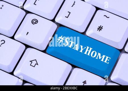 Eine Tastatur mit #StayHome auf einer blauen ENTER-Taste. Covid-19 Coronavirus-Pandemie bleibt zu Hause Lockdown-Konzept im April 2020. England, Großbritannien Stockfoto