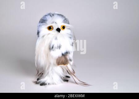 Spielzeug-Adler-Eule aus Naturfeder auf grauem Hintergrund Stockfoto