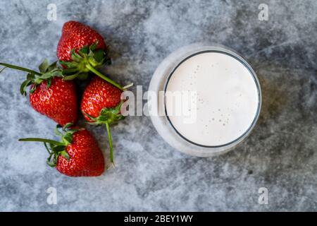 Kefir. Gesundes Bio trinkbarer Joghurt mit Erdbeeren Früchte im Glas / Buttermilch Ayran. Bereit zum Trinken. Stockfoto