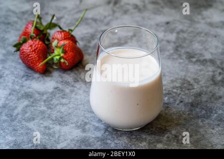 Kefir. Gesundes Bio trinkbarer Joghurt mit Erdbeeren Früchte im Glas / Buttermilch Ayran. Bereit zum Trinken. Stockfoto