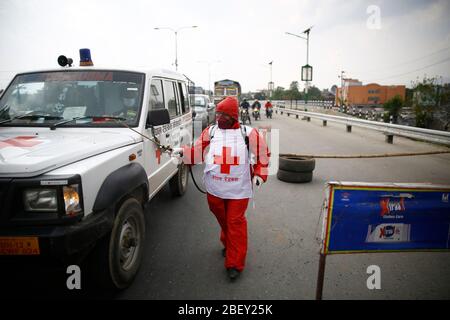 Kathmandu, Nepal. April 2020. Eine Frau vom Roten Kreuz desinfiziert Fahrzeuge an einem Polizeikontrollpunkt entlang der Grenze von Kathmandu und Bhaktapur am 24. Tag einer Regierung, die am Donnerstag, dem 16. April 2020, wegen der Ausbreitung der Coronavirus-Ansteckung in Nepal eine Sperre verhängt hat. Kredit: Skanda Gautam/ZUMA Wire/Alamy Live News Stockfoto