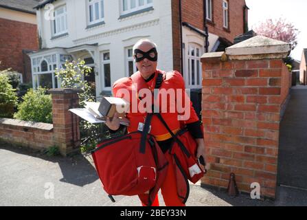 Loughborough, Leicestershire, Großbritannien. April 2020. Royal Mail Postmann Kevin Allen trägt Mr Incredible Fancy Dress zur Unterstützung des NHS, während er Post während der Coronavirus Pandemie Sperrung liefert. Credit Darren Staples/Alamy Live News. Stockfoto