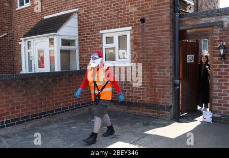 Loughborough, Leicestershire, Großbritannien. April 2020. Eine Postfrau aus Royal Mail trägt ein Smurf-Kleid zur Unterstützung des NHS, während sie während der Sperrung der Coronavirus-Pandemie Post abliefert. Credit Darren Staples/Alamy Live News. Stockfoto