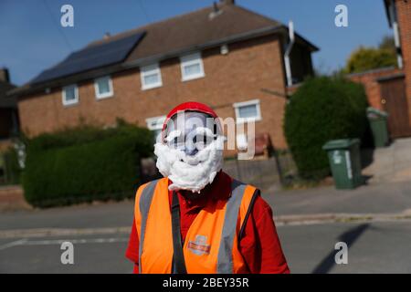 Loughborough, Leicestershire, Großbritannien. April 2020. Eine Postfrau aus Royal Mail trägt ein Smurf-Kleid zur Unterstützung des NHS, während sie während der Sperrung der Coronavirus-Pandemie Post abliefert. Credit Darren Staples/Alamy Live News. Stockfoto