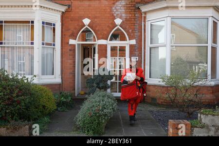 Loughborough, Leicestershire, Großbritannien. April 2020. Royal Mail Postmann Kevin Allen trägt Mr Incredible Fancy Dress zur Unterstützung des NHS, während er Post während der Coronavirus Pandemie Sperrung liefert. Credit Darren Staples/Alamy Live News. Stockfoto