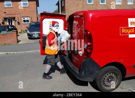 Loughborough, Leicestershire, Großbritannien. April 2020. Eine Postfrau aus Royal Mail trägt ein Smurf-Kleid zur Unterstützung des NHS, während sie während der Sperrung der Coronavirus-Pandemie Post abliefert. Credit Darren Staples/Alamy Live News. Stockfoto