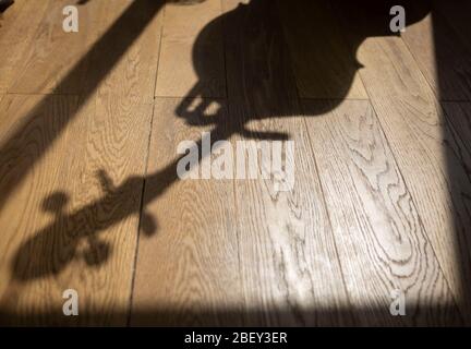Schatten eines Cellos auf einem Holzboden Stockfoto