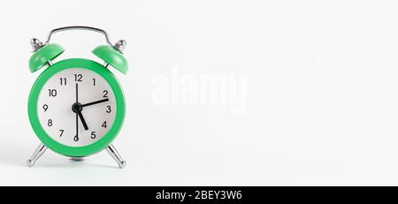 Grüner Wecker auf weißem Hintergrund. Banner, Kopierbereich. Stockfoto