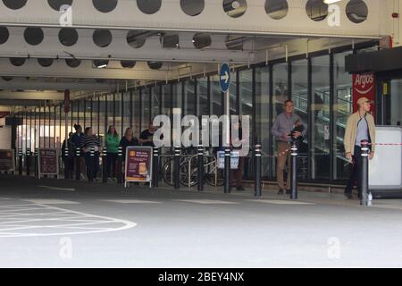 Shopper Queuing vor einem Sainsbury's Supermarkt in Edinburgh Stockfoto