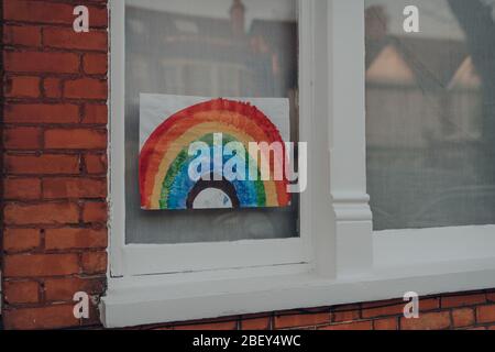 London, UK - 12. April 2020: Handgemachtes Regenbogenschild in einem Fenster eines Hauses in London, während Menschen sich gegenseitig unterstützen während der Sperrung wegen Stockfoto