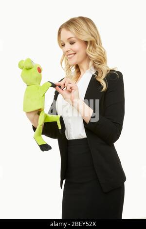 Blonde Geschäftsfrau mit einer Froschpuppe Stockfoto