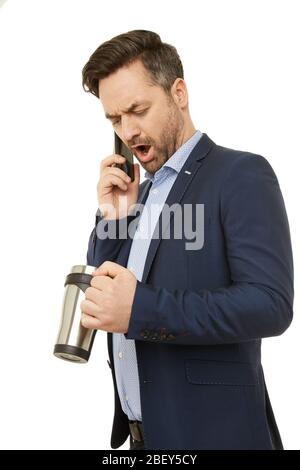 Ein Geschäftsmann spricht am Telefon und hält eine Kaffeetasse. Stockfoto