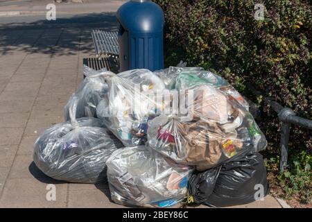 Bristol-April 2020-England-Nahaufnahme des Mülls, der sich neben einer öffentlichen Mülltonne auf einer Hauptstraße auftürmt Stockfoto