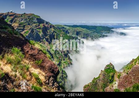 Herrliche Madeira-Insellandschaft. Blick von oben auf Canyon mit dichten Wolken und Bergkette mit Sternwarte auf Berggipfel bedeckt. Stockfoto