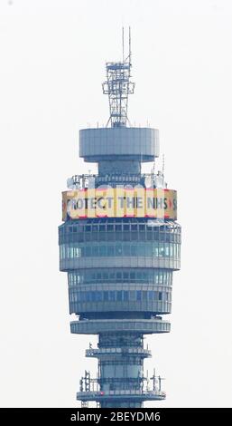 Die Botschaft der Regierung: "Bleibe heim, beschütze den NHS, rette Leben" wird in Lichtern auf dem rotierenden Display nahe dem BT Tower im Londoner Fitzrovia-Viertel gezeigt, während Großbritannien weiterhin in der Blockierung gegen die Coronavirus-Pandemie kämpft. Stockfoto