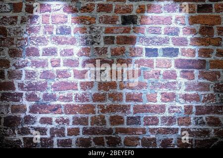 Zwei schöne blaue Scheinwerfer leuchten auf einer alten Ziegelwand Stockfoto