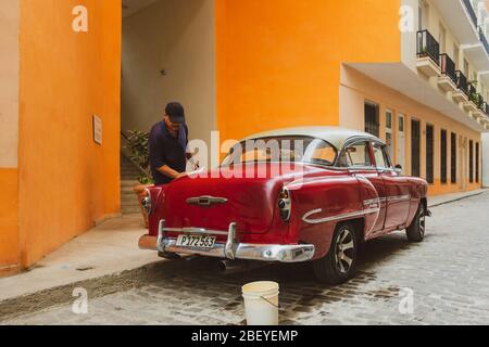 Person Polieren seiner alten Chevrolet Belair Oldtimer, Havanna Altstadt, Kuba Stockfoto