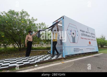 Guwahati, Assam, Indien. 15. April 2020. Ein Arbeiter, der in einen Corona Sanitisationstunnel kommt, bevor er in ein Quarantänezentrum am Sarusajai Sports Complex in Guwahati eintritt. Stockfoto