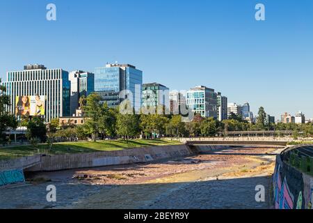 SANTIAGO, METROPOLREGION, CHILE. Skyline der Stadt, Blick vom Küstenpark. Mapocho Fluss im Vordergrund. Stockfoto