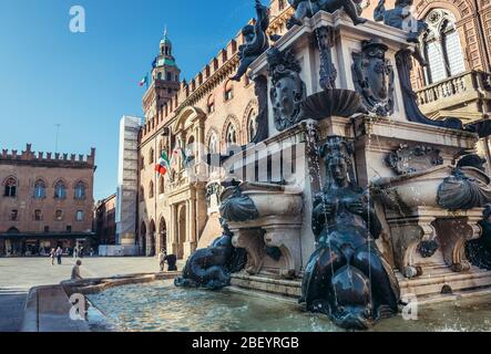 Neptunbrunnen auf der Piazza del Nettuno neben der Piazza Maggiore in Bologna in Italien, Blick mit Rathaus - Palazzo Comunale Stockfoto