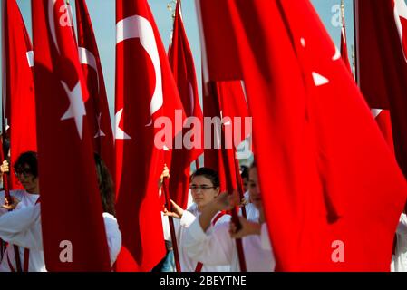 Izmir, Türkei - 29. Oktober 2016. Rote türkische Flaggen und junge Studentinnen halten sie bei der Zeremonie am Cumhuriyet Square Alsancak in Izmir. In Der Republik Stockfoto