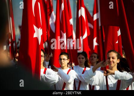 Izmir, Türkei - 29. Oktober 2016. Rote türkische Flaggen und junge Studentinnen halten sie bei der Zeremonie am Cumhuriyet Square Alsancak in Izmir. In Der Republik Stockfoto