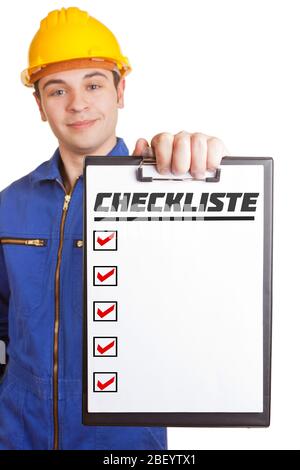 Handwerker in Overalls mit Schutzhelm hält ein Klemmbrett mit Checkliste Stockfoto