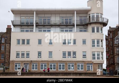 Portobello Beach, Edinburgh, Schottland, Großbritannien. April 2020. Temperatur 9 Grad mit dichter Wolke und fast leerer Promenade und Strand, was das Meer eher wie Winter als Frühling anfühlt.Bild: Die Wohnhäuser oberhalb des Beach Cafe, das derzeit nur Essen zum Mitnehmen anbietet. Obwohl einige Leute aus nehmen ihre erlaubte Ausübung, es scheint, dass die meisten Einwohner von Edinburgh beachten die Warnungen zu Hause bleiben während der Coronavirus Lockdown, die angeblich drei weitere Wochen dauern. Quelle: Arch White / Alamy Live News. Stockfoto