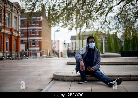 Ein Mann, der eine schützende Gesichtsmaske in Brixton, South London, trägt, während Großbritannien weiterhin in der Sperre bleibt, um die Ausbreitung des Coronavirus einzudämmen. Stockfoto