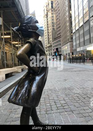 New York, USA. April 2020. Die Bronzestatue 'Fearless Girl' an der Wall Street trägt eine Atemschutzmaske. (An dpa: "New Yorks 'Fearless Girl' trägt jetzt eine Maske') Quelle: Benno Schwinghammer/dpa/Alamy Live News Stockfoto