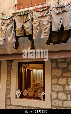 In den engen Gassen der Altstadt von Rovinj wird oft Wäsche an der Wäscheleine zum Trocknen aufgehängt. Manchmal sogar über dem Schaufenster des Schmuckwarenladens Stockfoto